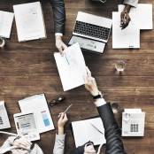 mensen vergaderen met laptop op tafel en papieren