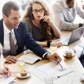 man legt iets uit aan groep mensen aan tafel